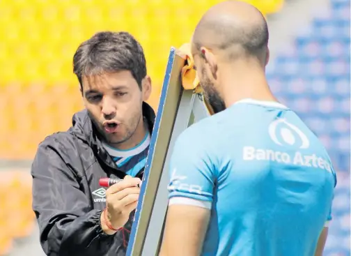  ?? /CORTESÍA CLUB PUEBLA ?? Nicolás Larcamón traza en el pizarrón la estrategia a seguir partido a partido