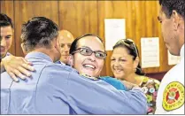  ??  ?? Jessica Cody hugs Andrew Moreira as she smiles at Lt. Juan Saavedra, two of the seven Palm Beach County Fire Rescue Station 42 members who responded to the emergency call in April.