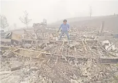  ??  ?? Marcelino Maceda looks for items in the remains of his mobile home after a wildfire sweep through the R.V. park destroying multiple homes in Estacada, Oregon.