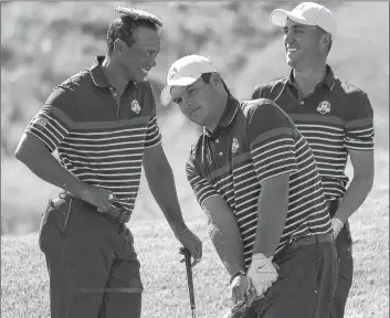  ?? AP PHOTO ?? Tiger Woods of the U.S .places the cover of a water sprinkler on his head as he jokes with Patrick Reeds, centre, and Jordan Spieth during a practice round for the Ryder Cup at Le Golf National in Saint-Quentin-en-Yvelines, outside Paris, France, Thursday.