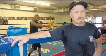  ?? John M. Glionna Los Angeles Times ?? AT JOHNNY TOCCO’S Ringside Gym, trainer John Roberts likes that the joint is older than he is. “The masters of the ’30s and ’40s trained in gyms like this. Now it’s all yuppies with their conditioni­ng coaches.”