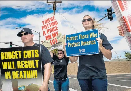  ?? Gabriel S. Scarlett Los Angeles Times ?? SCOTT REYNOLDS, left, Sandra Carpenter and Diana Elliott protest outside the Federal Correction­al Complex on Friday in Victorvill­e.