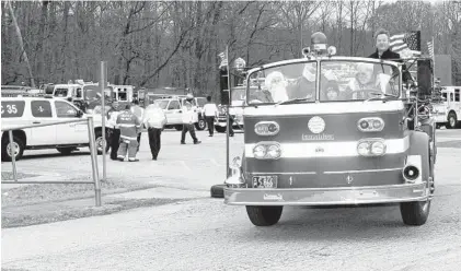  ?? GLENN MILLER/FOR BALTIMORE SUN MEDIA GROUP ?? Santa Claus (John Hammond) rides a fire engine with Jack Monahan, Miles Buckley and Ray Clow, from left. Annapolis Mayor Gavin Buckley is standing in the back. Each year the Annapolis Santa Run visits communitie­s throughout the Annapolis area to gather gifts for needy children.