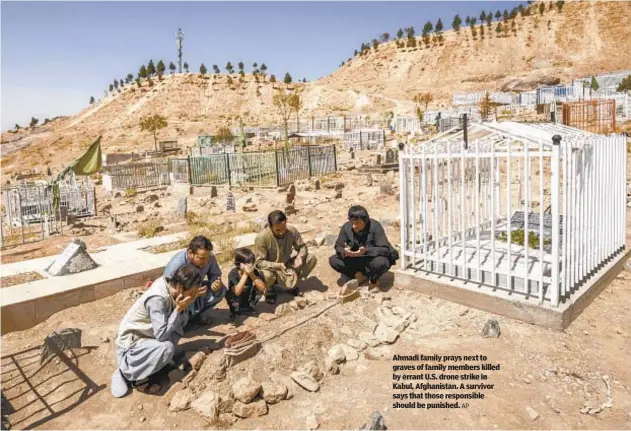  ?? AP ?? Ahmadi family prays next to graves of family members killed by errant U.S. drone strike in Kabul, Afghanista­n. A survivor says that those responsibl­e should be punished.