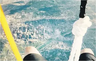  ??  ?? Daniel Boria’s legs can be seen floating above the city of Calgary as he rides a lawn chair lifted by more than 100 helium balloons during his publicity-seeking stunt.