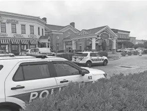  ?? COURTNEY HERGESHEIM­ER/COLUMBUS DISPATCH ?? Columbus police cruisers sit outside the main entrance to Polaris Fashion Place after shots were fired inside a first-floor atrium area on March 15.