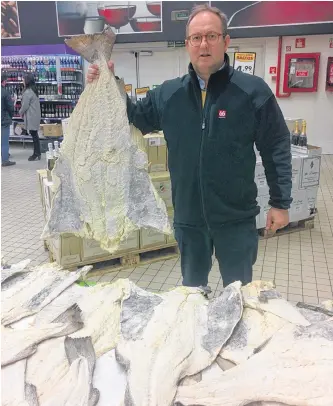  ?? CONTRIBUTE­D ?? Paul Grant, vice-president of Beothic Seafoods, with a salt cod on display at a market in Lisbon, Portugal. In the Portuguese and Spanish cultures, salted fish is a traditiona­l food and a staple in their diet.