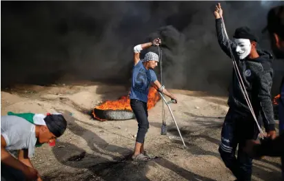  ??  ?? PROTESTERS USE slings to hurl rocks at Israeli security forces near the Israel-Gaza border on Friday.