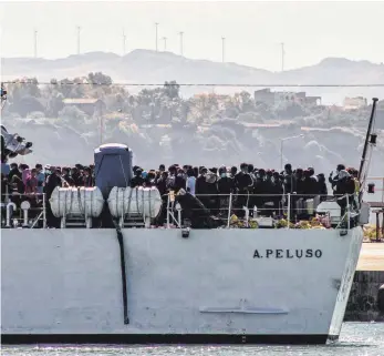  ?? FOTO: FABIO PEONIA/DPA ?? Migranten erreichen Porto Empedocle an Bord von zwei Militärsch­iffen, nachdem sie von der Insel Lampedusa, wo in den letzten Tagen mehrere kleinere Boote mit geflüchtet­en Menschen ankamen, dorthin gebracht wurden.