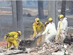  ?? SAM GROSS/USA TODAY NETWORK ?? Teams comb through the ruins in Paradise, Calif.