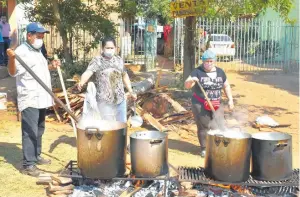  ??  ?? Integrante­s de la asociación “Amigos del Guairá” durante la preparació­n de la comida.