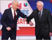  ??  ?? An elbow bump greeting for Biden and Sanders