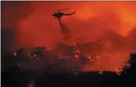  ?? NOAH BERGER — THE ASSOCIATED PRESS ?? A helicopter drops water on the Cave Fire burning along Highway 154 in Los Padres National Forest above Santa Barbara on Tuesday.