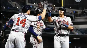  ?? MATT YORK/ASSOCIATED PRESS ?? Austin Riley high-fives Adam Duvall as Freddie Freeman looks on after Riley’s two-run home run — his 30th of the season — gave the Braves an early lead in Tuesday night’s 6-1 win over Arizona.