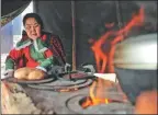  ??  ?? Suoyulan makes Russian bread in the settlement of Aoluguya Ewenki ethnic township. The bread, made from flour and reindeer milk, is the traditiona­l staple food of the Ewenki people.