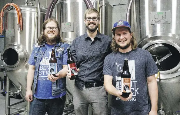  ?? CODIE MCLACHLAN ?? From left, Kurtis Jensen, Scott Kendall and Ben Rix of Bent Stick Brewing show off some of their products in their Edmonton microbrewe­ry. Using Alberta barley, Bent Stick makes a British-style ale that carbonates in the bottle.