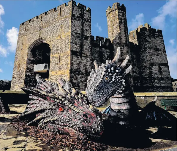  ??  ?? > Dewi and Dwynwen have a cwtch outside Caernarfon Castle as part of the St David’s Day celebratio­ns