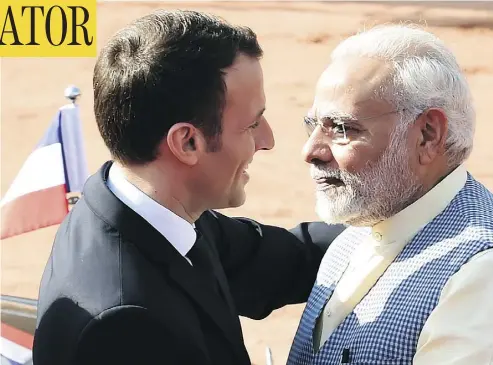  ?? MONEY SHARMA/AFP/GETTY IMAGES ?? India’s Prime Minister Narendra Modi, right, greets France’s President Emmanuel Macron upon his arrival at the Presidenti­al Palace in New Delhi on Saturday — a welcome that sharply contrasted the cool one given Justin Trudeau.