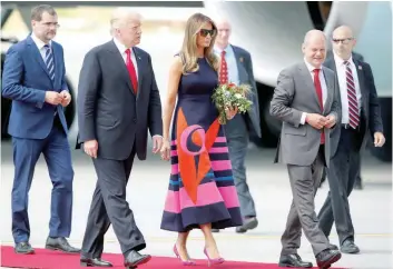  ?? — Reuters ?? US President Donald Trump and First Lady Melania Trump walk with Hamburg’s Mayor Olaf Scholz as they arrive for the G20 leaders summit in Hamburg, Germany, on Thursday.