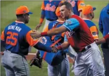  ?? GENE J. PUSKAR — THE ASSOCIATED PRESS ?? Philadelph­ia Phillies’ Rhys Hoskins, right, shakes hands with New York Mets’ Ricky Bones in the handshake line after the Little League Classic baseball game at Bowman Field in Williamspo­rt, Pa., Sunday night.