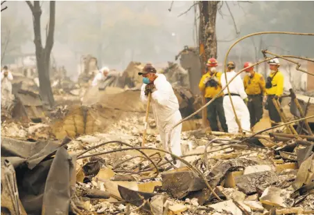  ?? Scott Strazzante / The Chronicle ?? Fire crews search for victims amid the rubble of the Shelter Cove Apartments in Paradise in the fire’s aftermath.