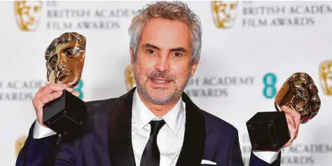  ?? BEN STANSALL / AFP/Getty Images ?? Alfonso Cuaron posa con los premios que obtuvo con ‘Roma’ en los premios BAFTA, en Londres.