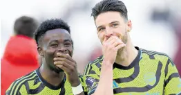  ?? AP ?? Arsenal’s Declan Rice (right) smiles as he talks to teammate Bukayo Saka at the end of the English Premier League match between West Ham United and Arsenal at the London Stadium yesterday. Arsenal won the game 6-0.