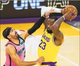  ?? Mark J. Terrill Associated Press ?? LeBRON JAMES started out strong against Gabe Vincent and Miami on Saturday, but his shooting cooled off and the defense forced the ball out of his hands.