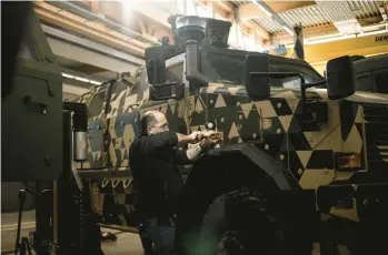  ?? JIM HUYLEBROEK/THE NEW YORK TIMES ?? A mechanic works on a German-made Dingo reconnaiss­ance vehicle Feb. 9 at a military facility in Luxembourg. With a limited military arsenal on hand, the tiny country is instead using its money to help arm Ukraine.