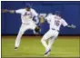  ?? KATHY WILLENS - THE ASSOCIATED PRESS ?? New York Mets center fielder Juan Lagares (12) and Mets left fielder Alejandro De Aza (16) celebrate after the second game of a doublehead­er against the St. Louis Cardinals, Tuesday in New York. The Mets defeated the Cardinals 3-1.