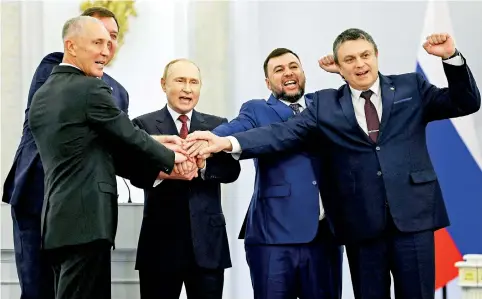  ?? ?? (L-R) The Moscow-appointed heads of Kherson region Vladimir Saldo and Zaporizhzh­ia region Yevgeny Balitsky, Russian President Vladimir Putin, Donetsk separatist leader Denis Pushilin and Lugansk separatist leader Leonid Pasechnik join hands after signing treaties formally annexing four regions of Ukraine Russian troops occupy.
(SPUTNIK/AFP)