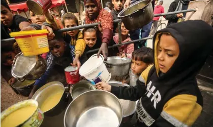  ?? ?? Palestinia­n children wait to receive food cooked by a charity kitchen in Rafah. Photograph: Ismael Mohamad/UPI/Rex/Shuttersto­ck