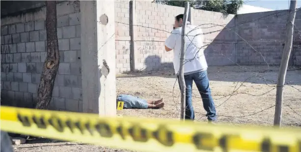  ?? FOTO: ÁNGEL ZAMUDIO ?? &gt; Personal pericial fotografía el cadáver para anexarlo al historial de crímenes.
