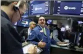  ?? RICHARD DREW — THE ASSOCIATED PRESS ?? Specialist Peter Giacchi, center, stands on the floor of the New York Stock Exchange, Tuesday. Spotify Inc. will make its stock market debut Tuesday, casting a spotlight on its early lead in music streaming.