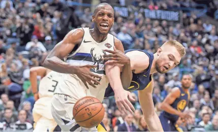  ?? BENNY SIEU / USA TODAY SPORTS ?? The Bucks' Khris Middleton and Pacers' Domntas Sabonis get tangled as Middleton loses the ball Friday night. Middleton had a game-high 30 points.