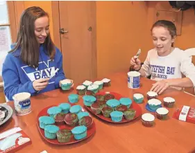  ?? MICHAEL SEARS / MILWAUKEE JOURNAL SENTINEL ?? Rachel Abramson (left) and Madeline Kogler, both 13, decorate cupcakes for C hristmas and Hanuukah. Madeline has enjoyed learning about Hanukkah from Rachel.