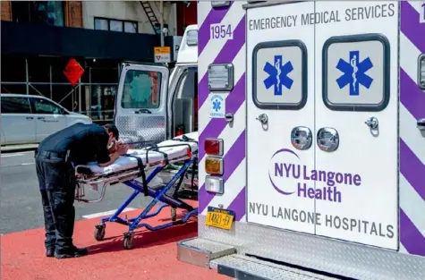  ?? David Dee Delgado/Getty Images ?? An EMT takes a moment Tuesday in front of NYU Langone Hospital in New York City. Gov. Andrew Cuomo said in his Tuesday briefing that 731 people had died of COVID-19 since Monday, the state’s highest one-day total.