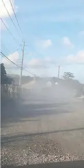  ??  ?? Clouds of dust rise constantly from the Port Morant main road.