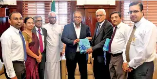  ??  ?? Dr. Indrajit Coomaraswa­my, Governor of the Central Bank presents the Annual Report 2018 to Mangala Samaraweer­a, Finance Minister in the presence of Eran Wickramara­tne, State Minister of Finance, and senior bank officials.