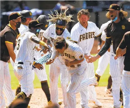  ?? K.C. ALFRED U-T ?? Will Myers, who isn’t big on “swag,” gets mobbed by teammates after hitting a walk-off homer against the Mariners last season.