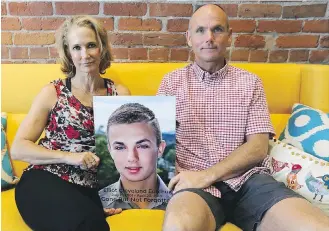  ??  ?? Rachel Staples and Brock Eurchuk with a photo of their son Elliot.