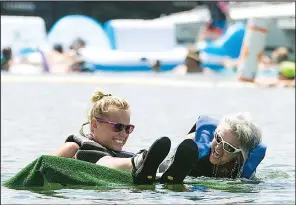  ?? Democrat-Gazette file photo ?? Dezirae Plummer (left) and Tresia Orellana experience that sinking feeling at last year’s World Championsh­ip Cardboard Boat Races in Heber Springs.