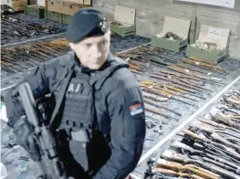  ?? Reuters ?? A police officer stands guard in front of the weapons handed over to police in the first 10 days of gun amnesty, near Smederevo, Serbia. —