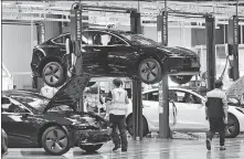  ?? DING TING / XINHUA ?? Technician­s work at the Tesla Gigafactor­y in Shanghai in November 2020.
