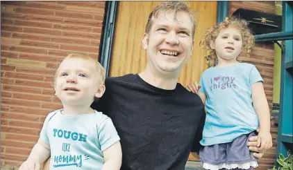  ?? AP PHOTO ?? In this July 8 photo, Chris Guerin poses for a photo with his children Charlie, 3, (right) and Danny in Portland, Ore. For parents looking to dress their kids in clothing that defy gender norms, options for the back-to-school shopping season are still...