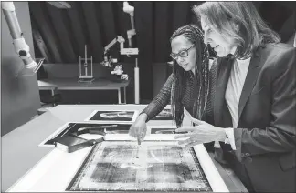  ?? MICHEL DE GROOT / THE NEW YORK TIMES ?? Abbie Vandivere, left, paintings conservato­r at the Mauritshui­s Royal Picture Gallery, and Emilie Gordenker, museum director, examine an X-ray photo of Johannes Vermeer’s “Girl with a Pearl Earring” on Feb. 15 in The Hague, Netherland­s. Researcher­s...