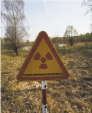  ?? Sergei Grits / Associated Press ?? A radiation warning appears inside the exclusion zone around the Chernobyl nuclear reactor.