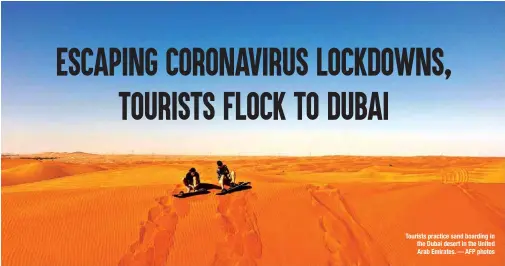  ??  ?? Tourists practice sand boarding in the Dubai desert in the United Arab Emirates.