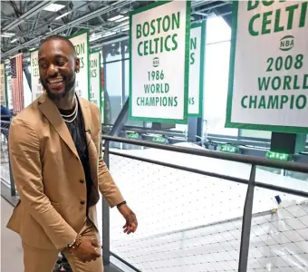  ?? CHRISTOPHE­R EVANS / BOSTON HERALD ?? HISTORY TOUR: Kemba Walker walks past Celtics championsh­ip banners yesterday at the Auerbach Center, where he and fellow newcomer Enes Kanter were introduced; below, Walker shakes hands with Celtics coach Brad Stevens.