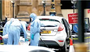  ?? — Gambar Henry Nicholls/Reuters ?? PEGAWAI forensik memeriksa kereta yang merempuh perintang di luar Bangunan Parlimen di Westminste­r, London, Britain kelmarin.